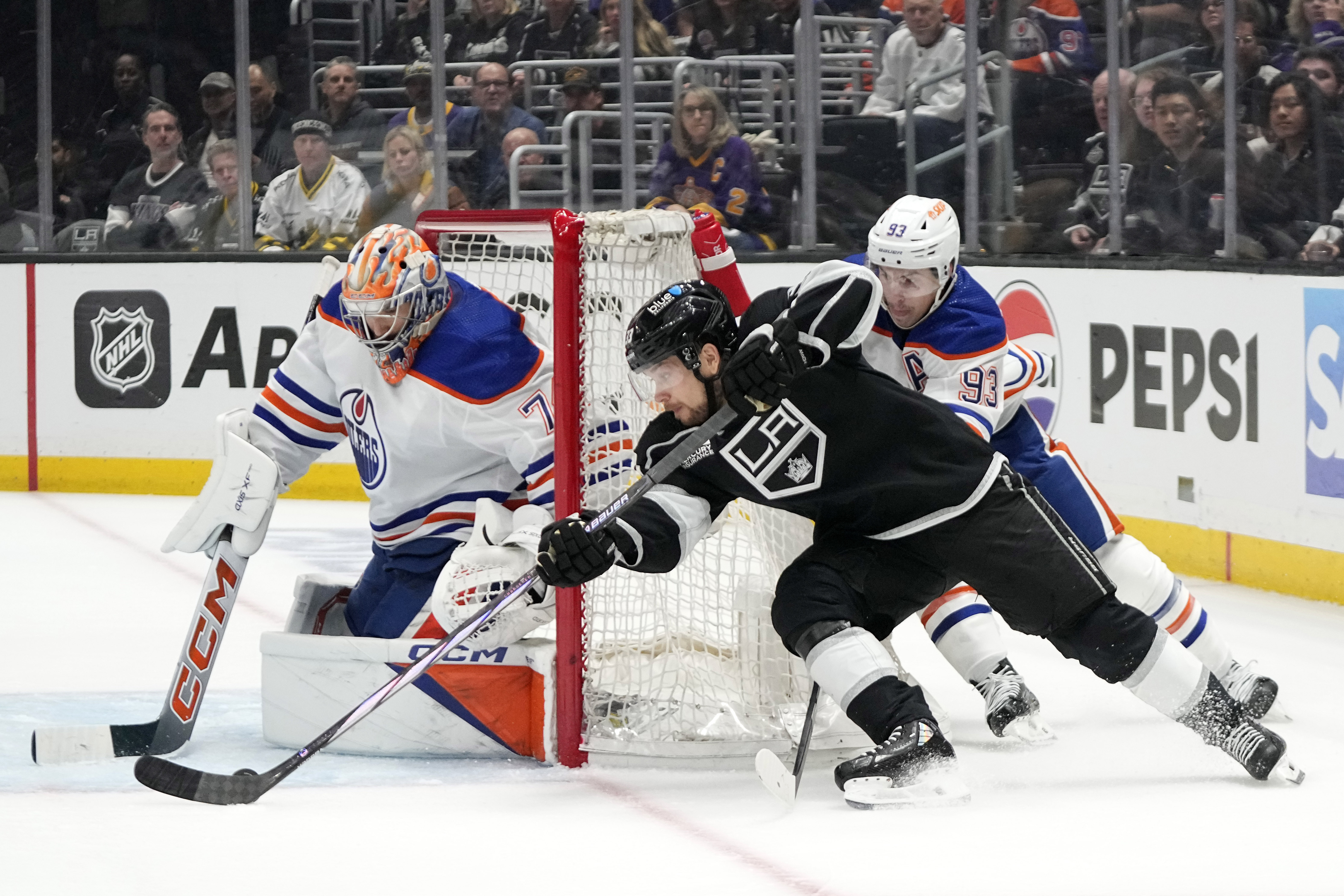 Los Angeles Kings right wing Viktor Arvidsson, center, tries to...