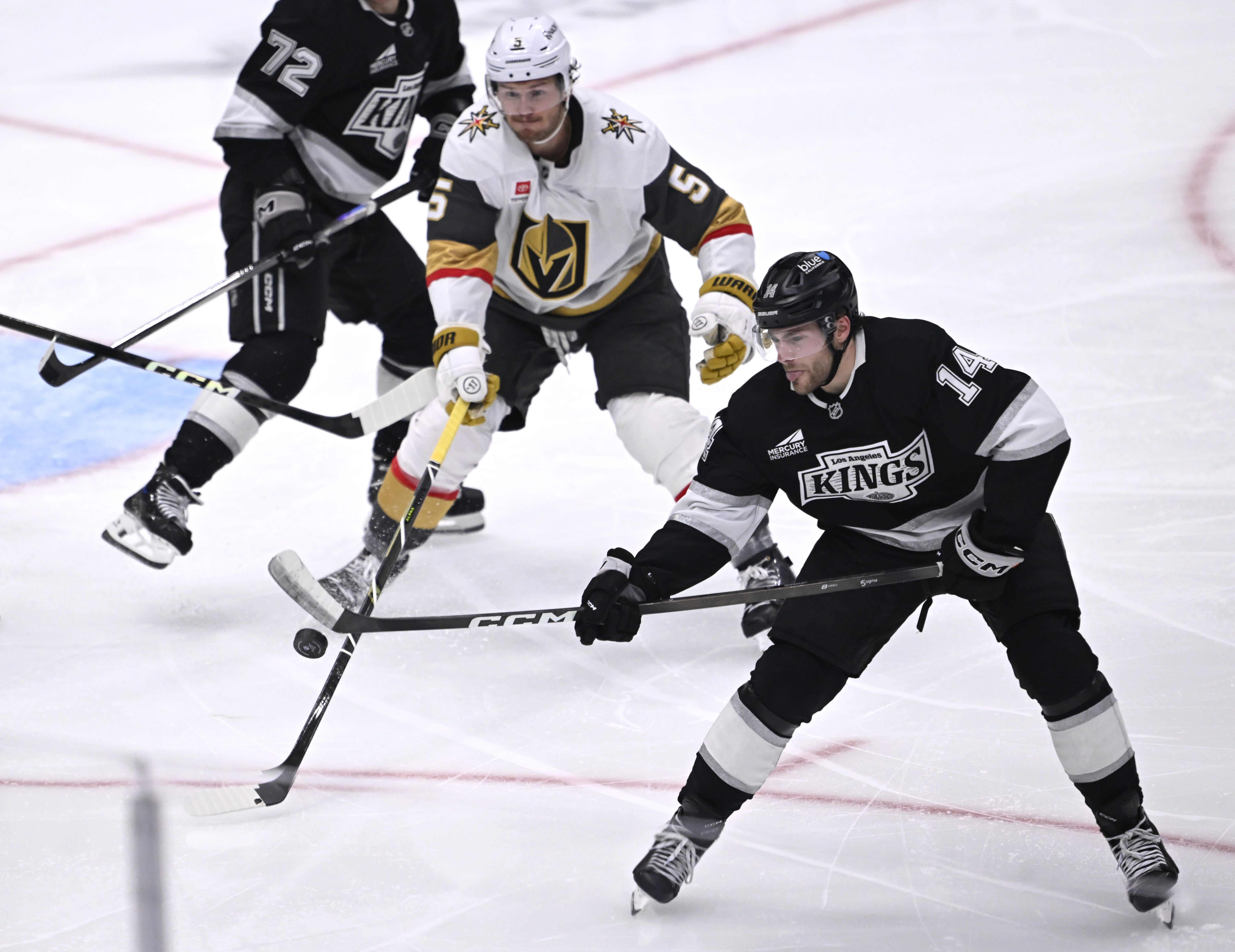 Kings right wing Alex Laferriere, right, battles for the puck...