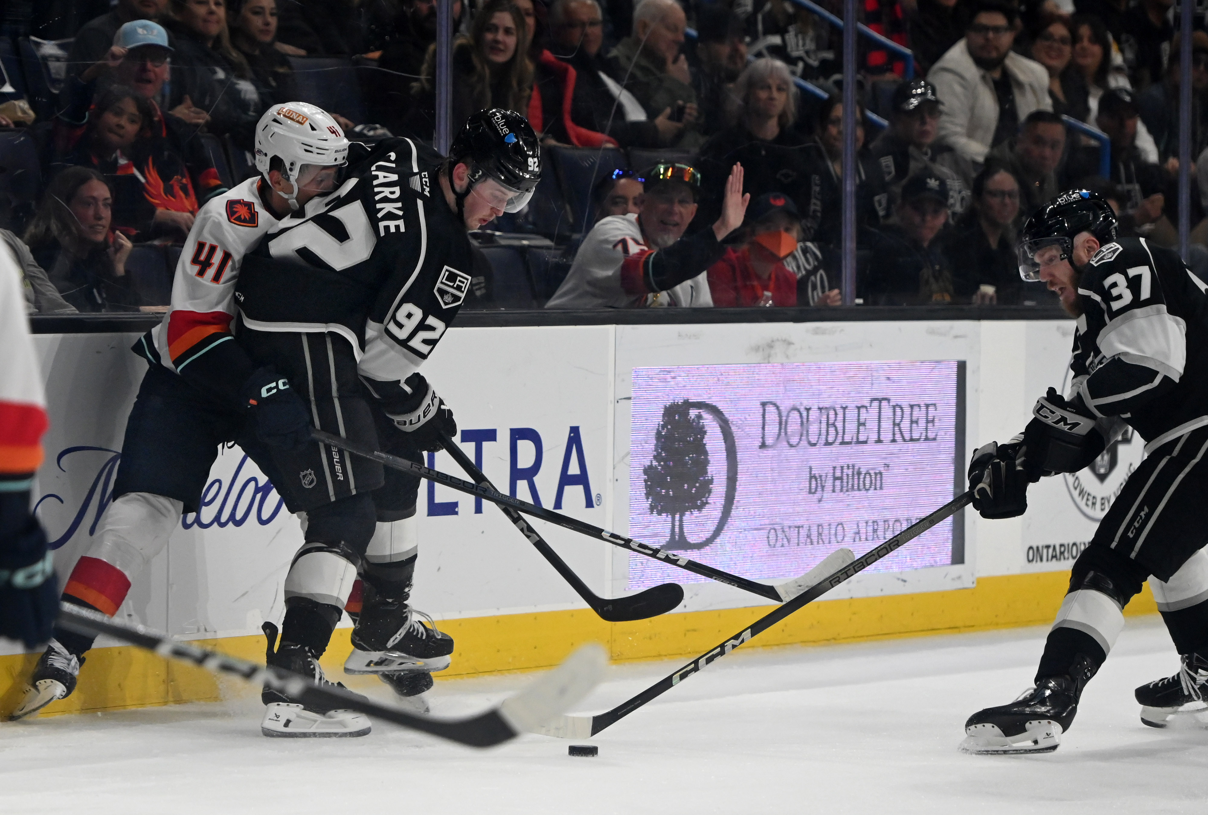 Ontario Reign’s Bramdt Clarke and Jacob Doty shield the puck...