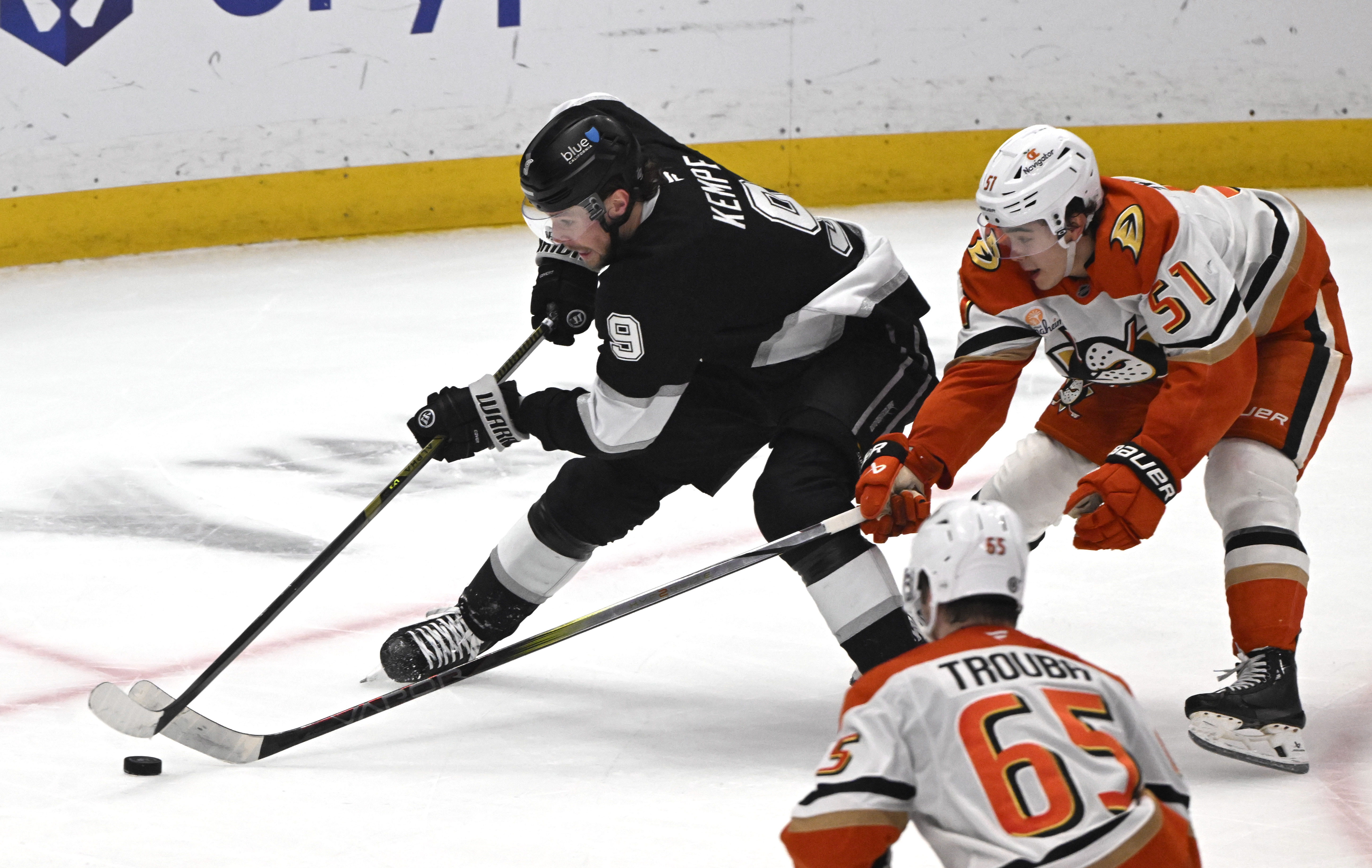 The Kings’ Adrian Kempe, left, controls the puck as the...