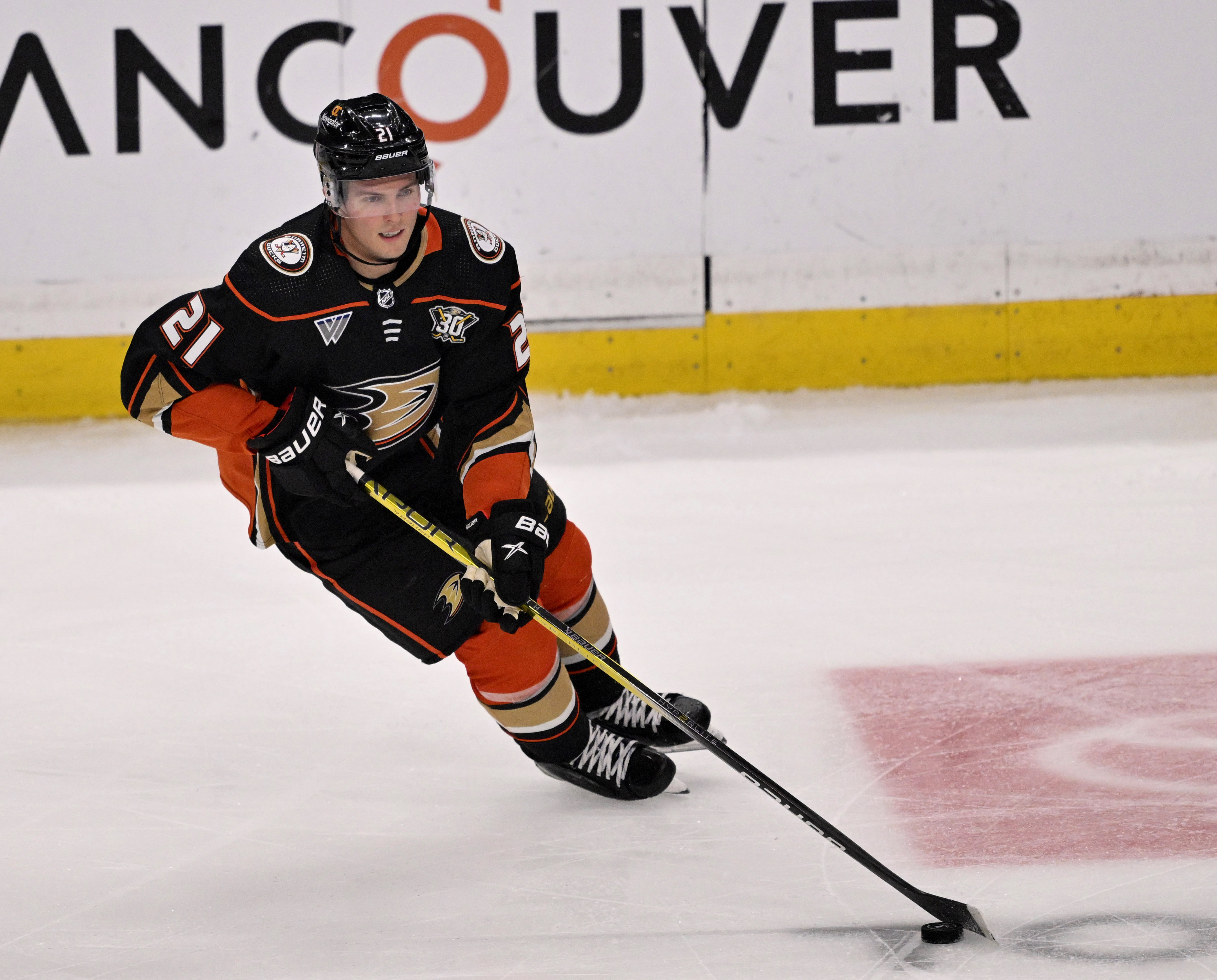 Isac Lundestrom #21 of the Anaheim Ducks controls the puck...