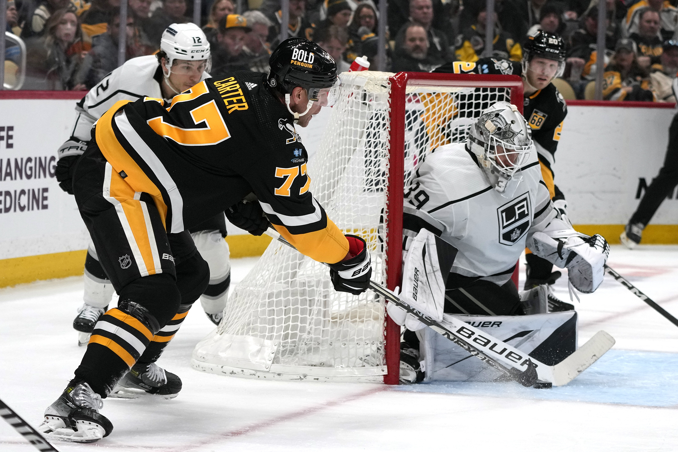 Pittsburgh Penguins’ Jeff Carter (77) can’t get a wrap-around attempt...
