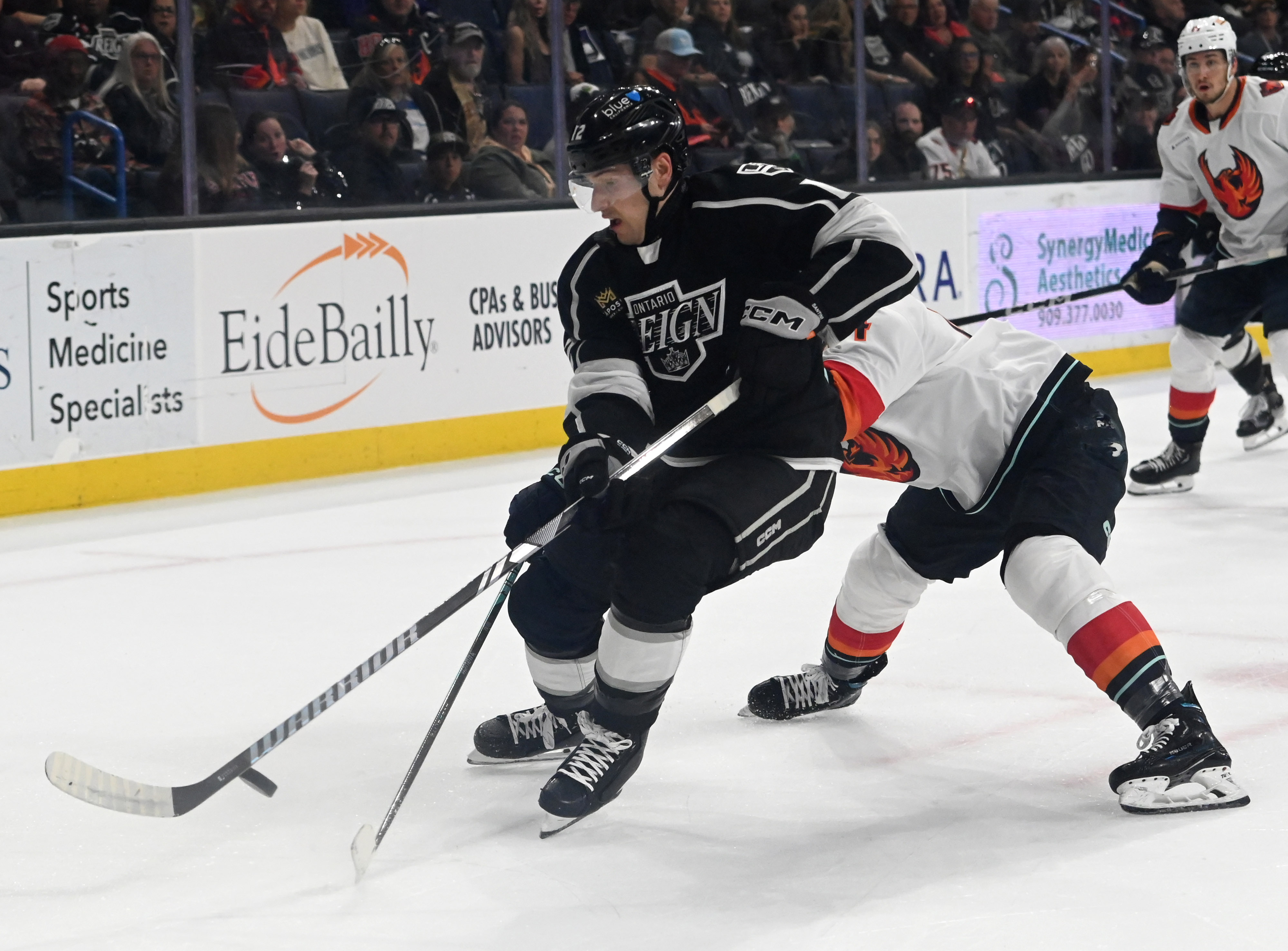 Ontario Reign’s Steven Santini dribbles the puck pressured by Coachella...