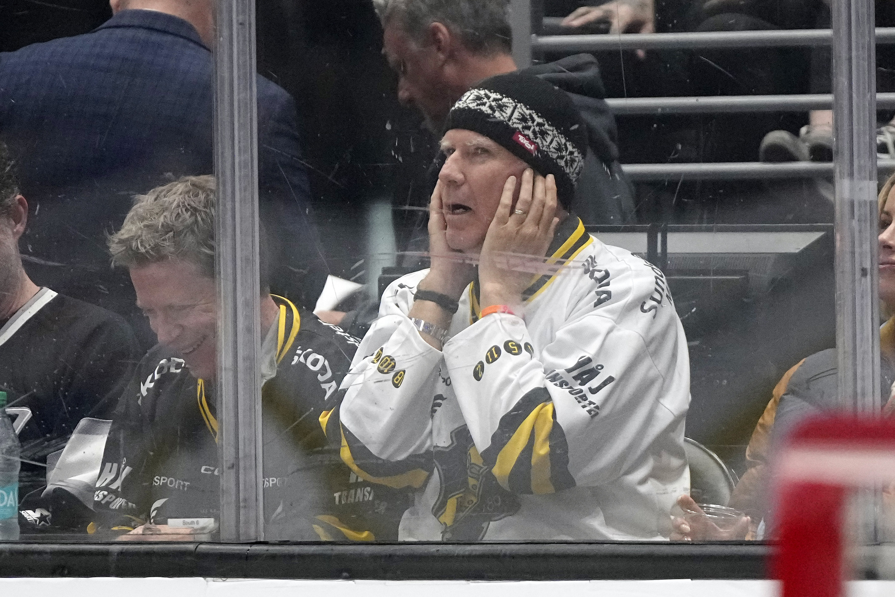 Actor Will Ferrell covers his ears as the crowd is...