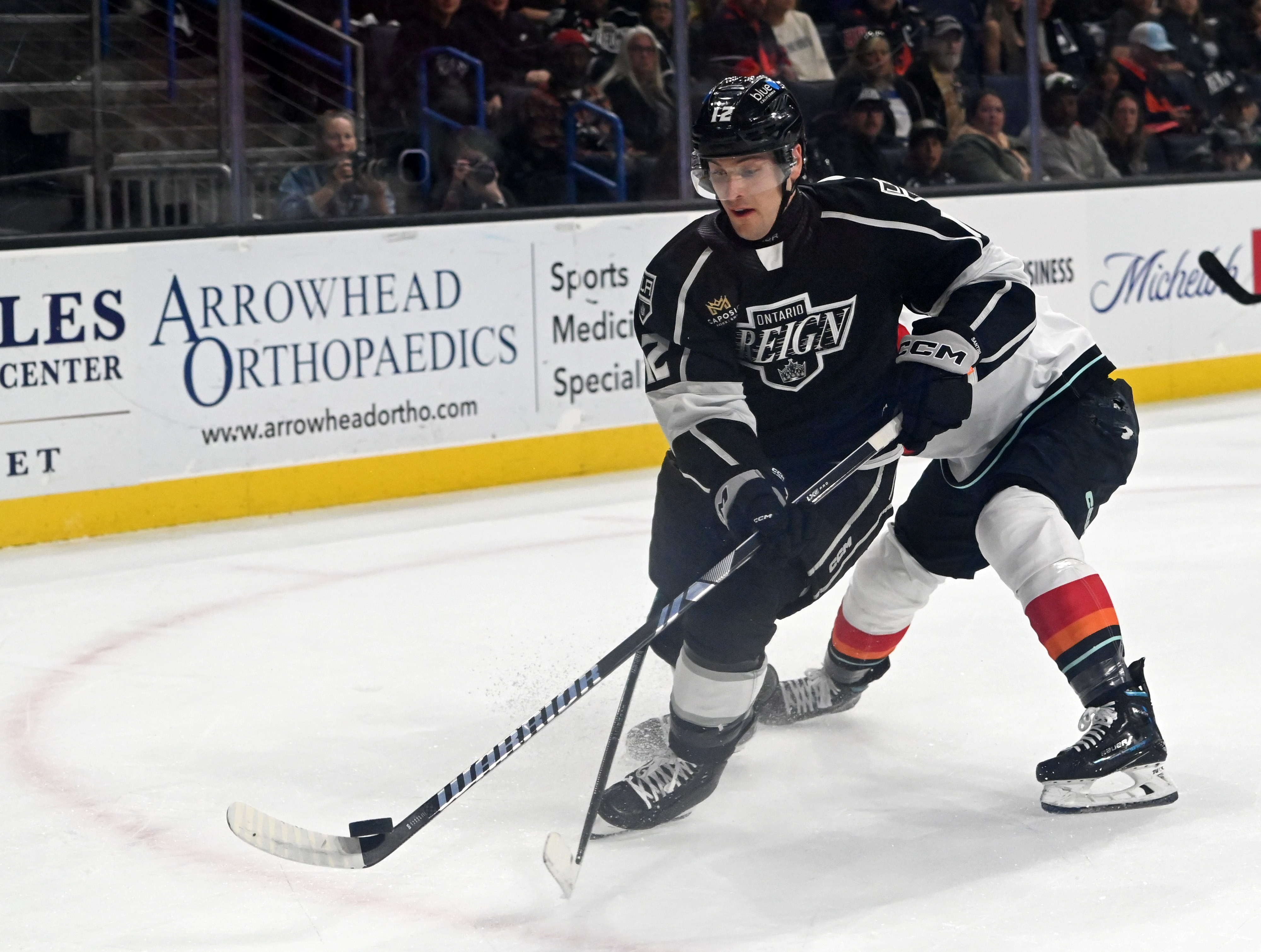 Ontario Reign’s Steven Santini dribbles the puck pressured by Coachella...
