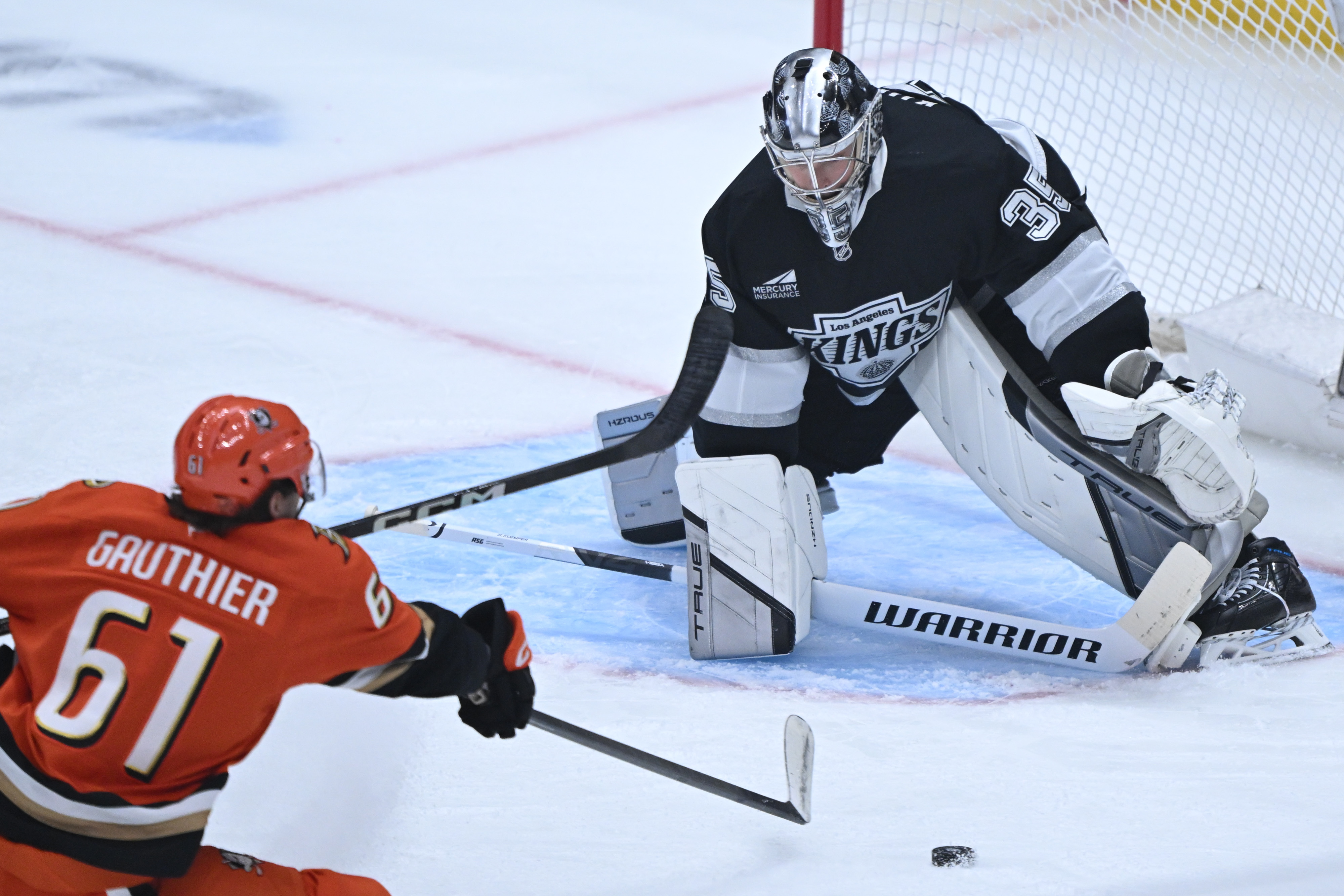 The Ducks’ Cutter Gauthier, left, shoots the puck as Kings...