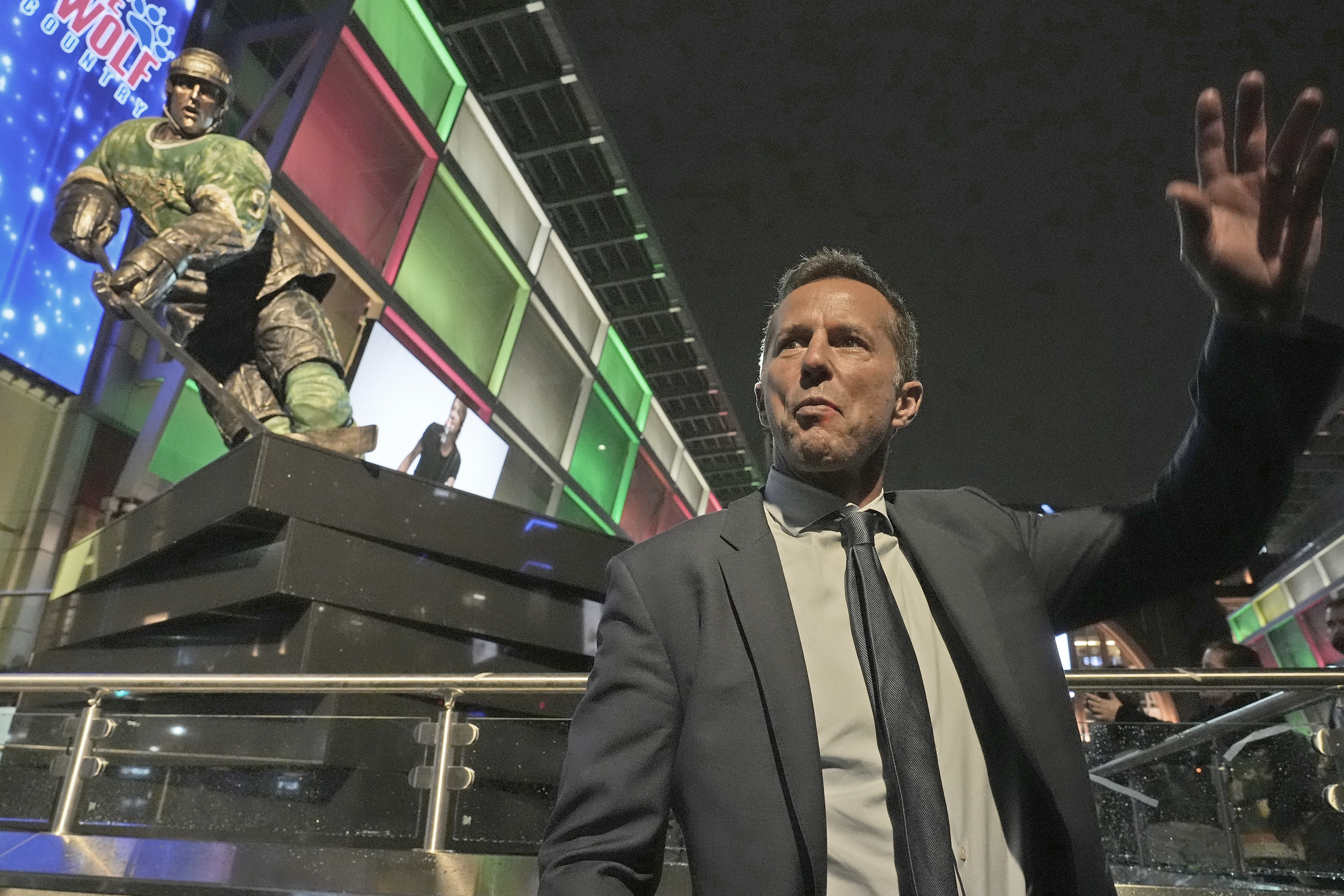 Former Dallas Stars player Mike Modano waves to fans in...