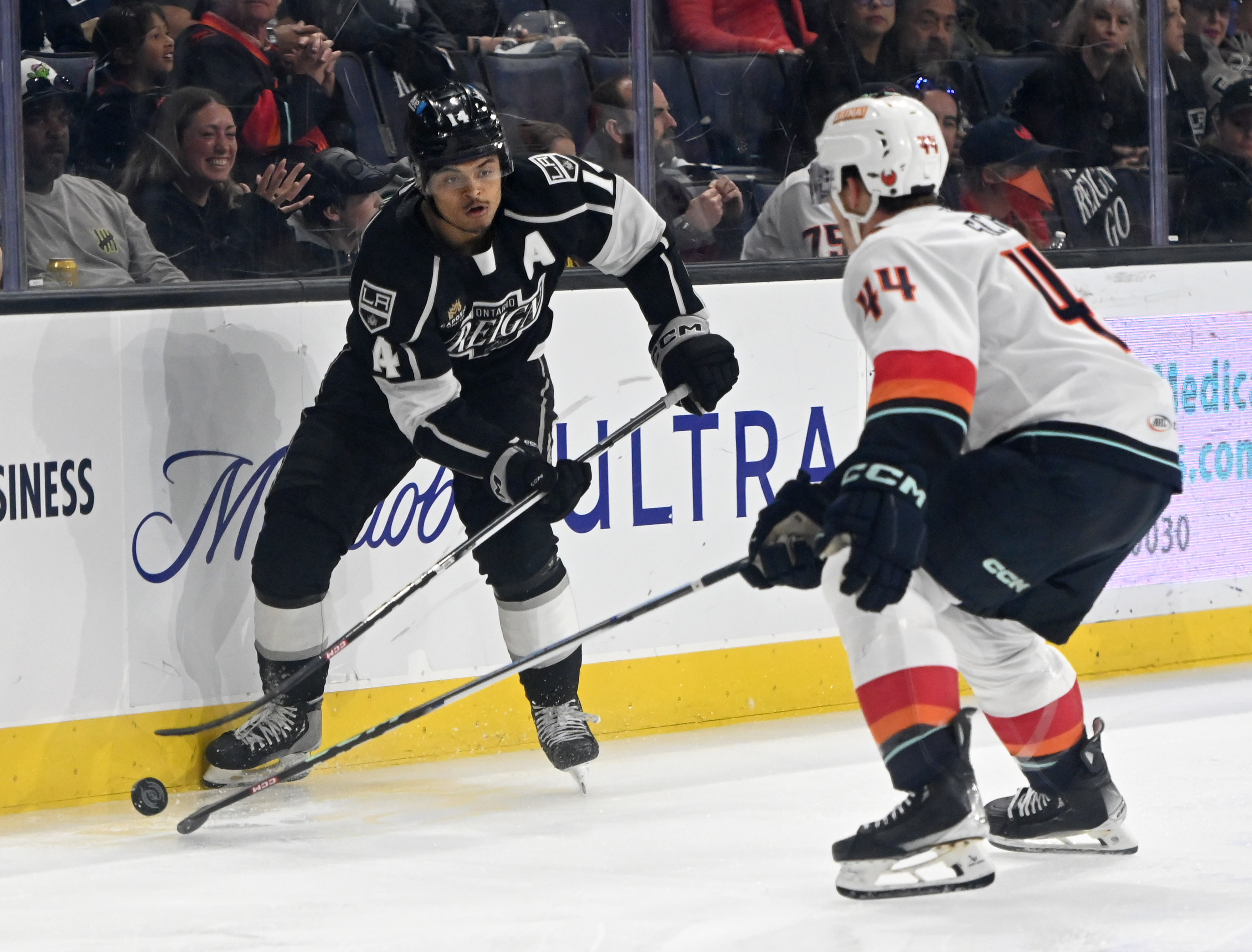 Ontario Reign’s Akil Thomas is pressured by Coachella Valley Firebirds’...