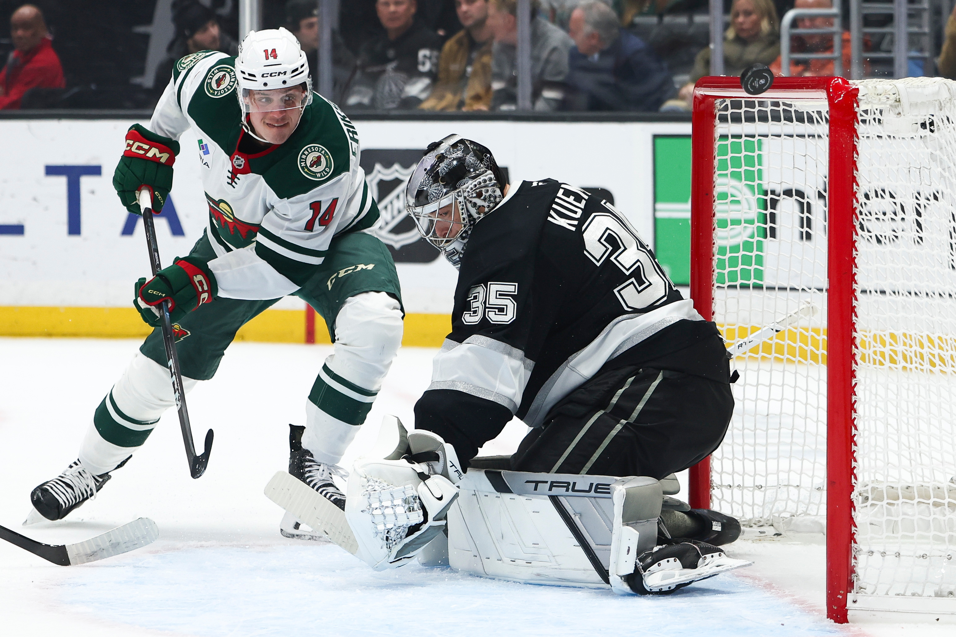 Minnesota Wild center Joel Eriksson Ek, left, watches the puck...