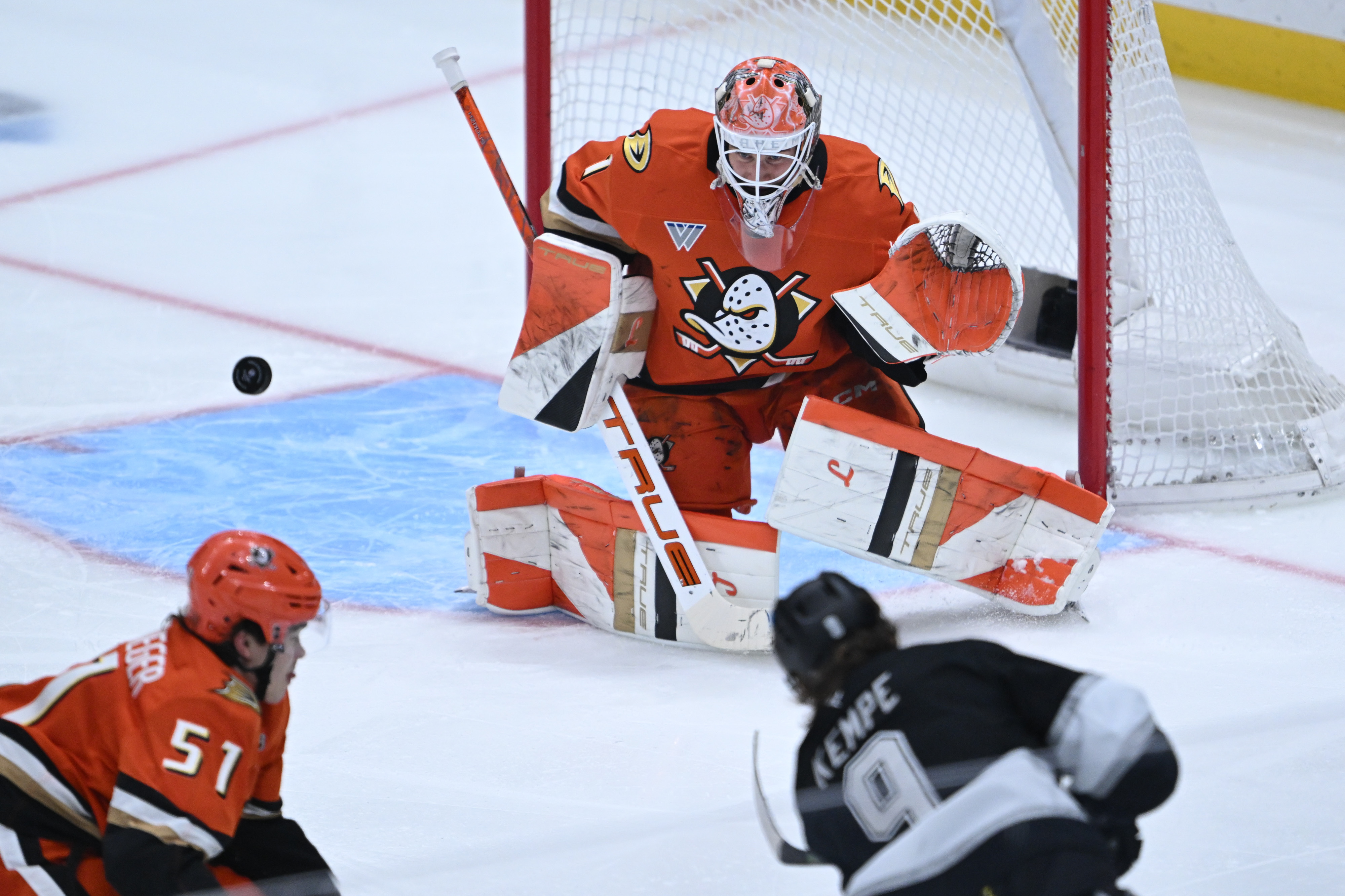 Ducks goaltender Lukas Dostal, top, deflects a shot by the...
