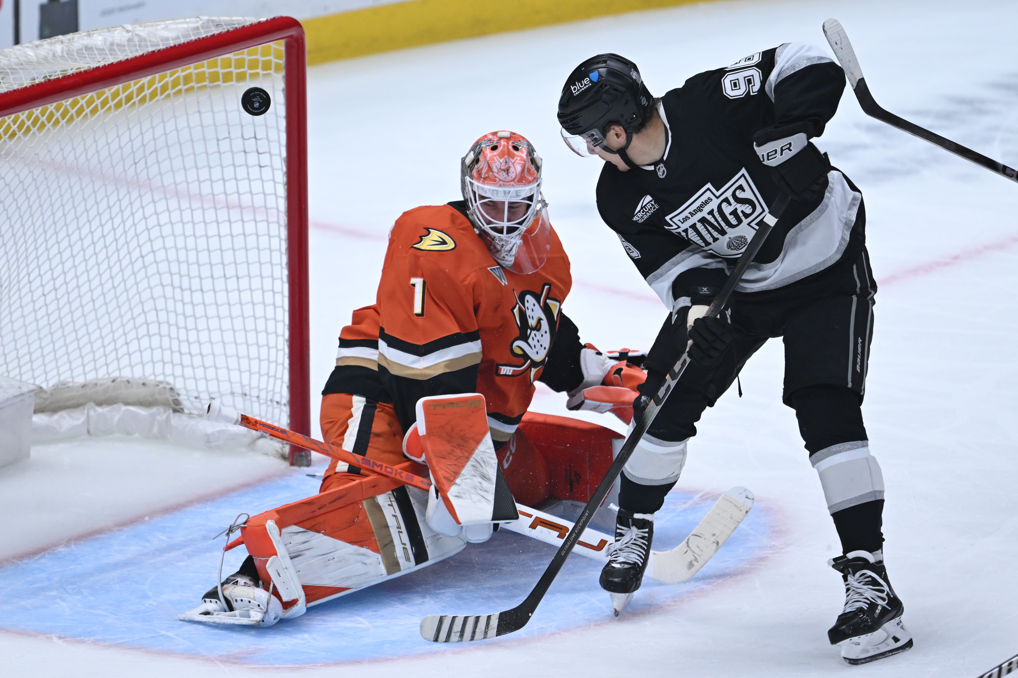 The Kings’ Andrei Kuzmenko, right, has his shot deflected by...