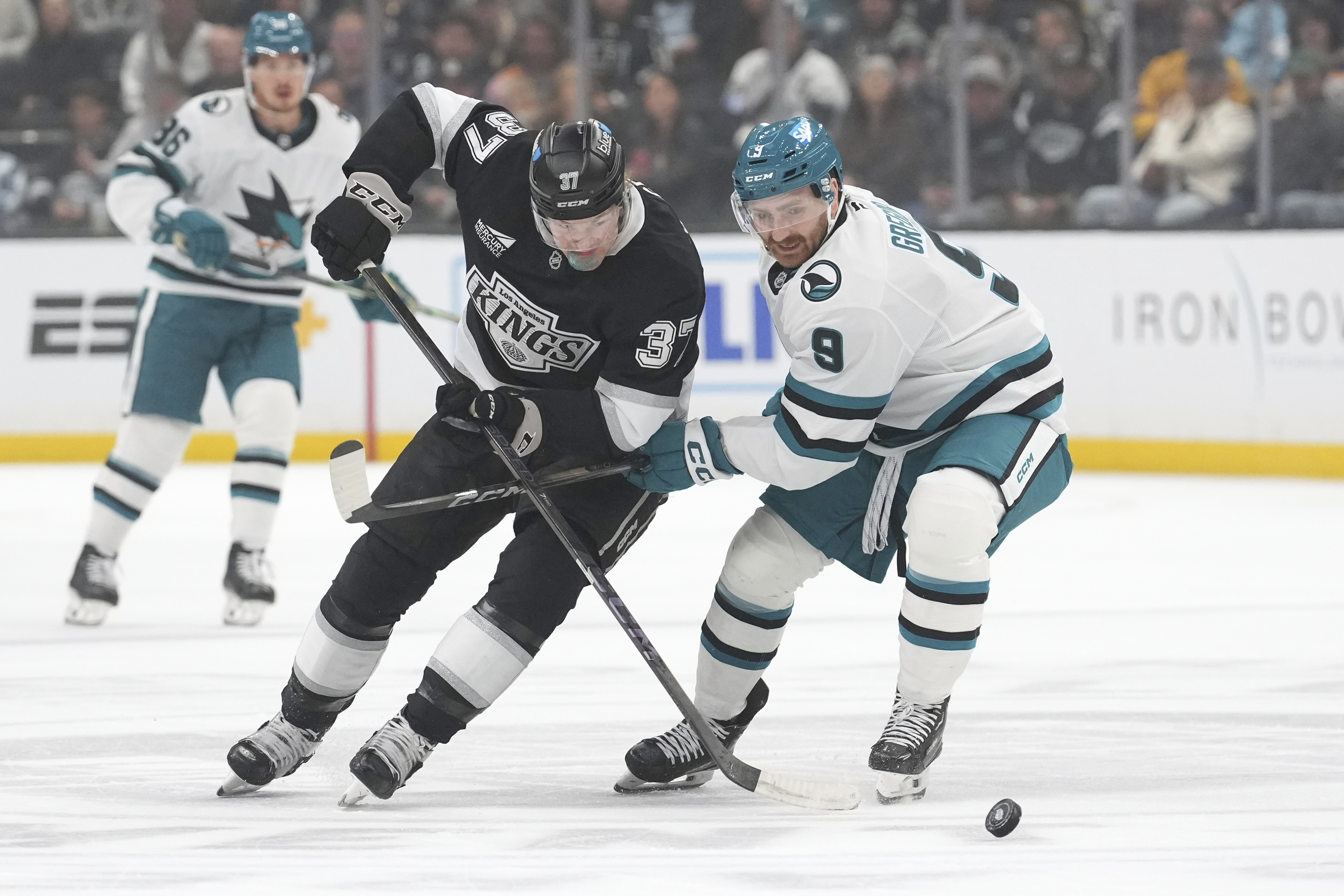 Kings left wing Warren Foegele, center, and San Jose Sharks...